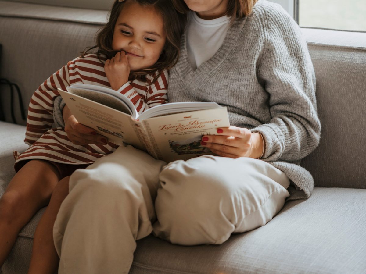 A carer sat reading together with a child, warm and candid
