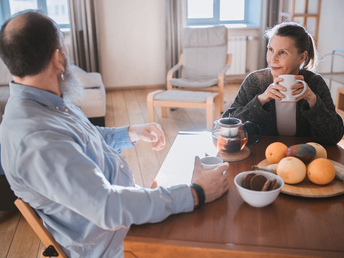 A carer and adult client sharing tea and fruit at home